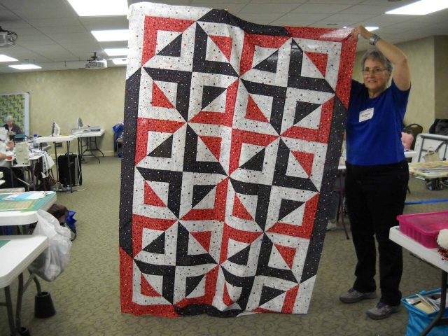 Barbara-S.-shows-her-Quilt-of-Honor-scaled