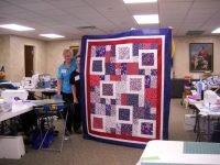 Karen-M.-shows-her-Quilt-of-Honor-scaled